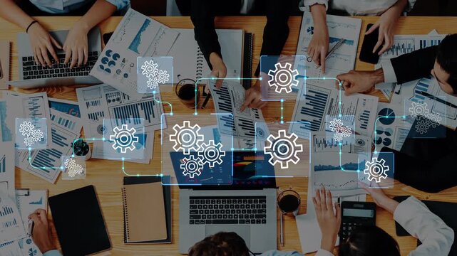 A diverse business team engages in a collaborative data analysis session, surrounded by charts and technology, focusing on strategies for growth and innovation in a modern workspace. Entropy.