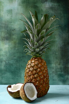 Different types of exotic fruits : pineapple, coconut, banana, orange, persimmon and pomegranate.