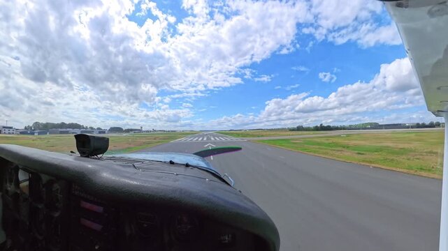 Cockpit view Cessna 172 Skyhawk landing on a large paved airport runway, approaching touchdown during general aviation flight on a clear airfield in daylight