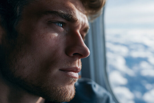 Pensive Young Man Looking Through Airplane Window