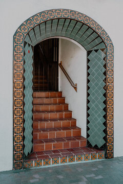 Colorful tiled entrance to a front door located at the top of a staircase. 