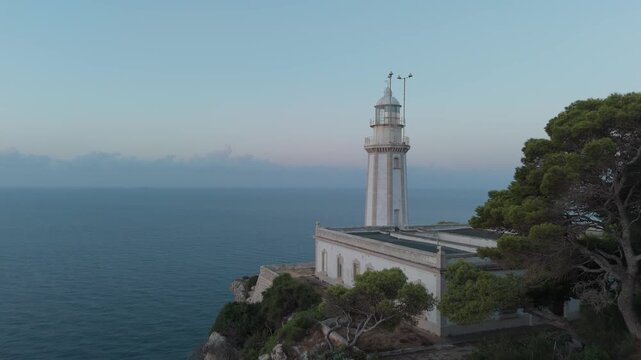 Drone flying towards la nao lighthouse at sunset in javea spain