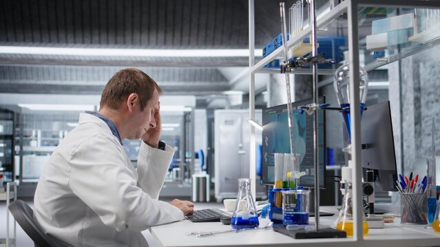 Dissatisfied scientist struggles with complicated experiment data in a laboratory while facing biotechnology and genetics research challenges.