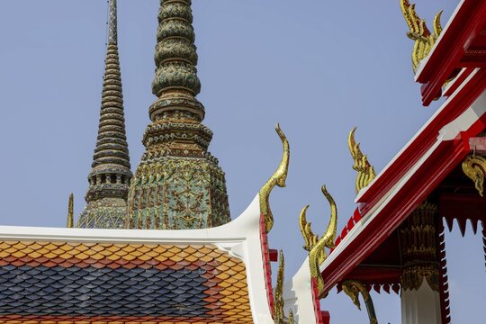 Golden mosaic ornaments rise like flames to heaven carried by Chofa and Bai Raka on the ornate pediment of the Wat Pho Temple, a brilliant detail of Thai religious architecture, Wat Pho, Bangkok, Thailand