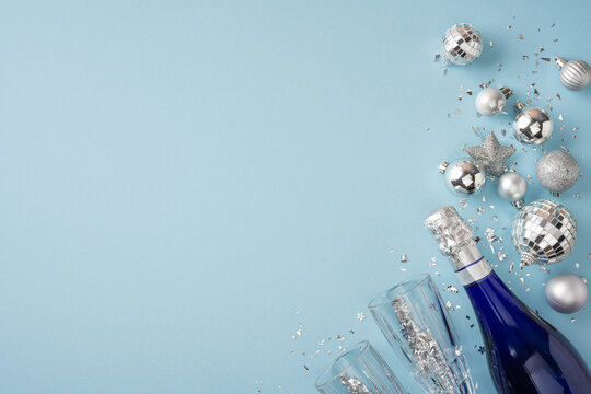 Happy New Year 2027 celebration with champagne bottle and silver holiday decorations on blue background