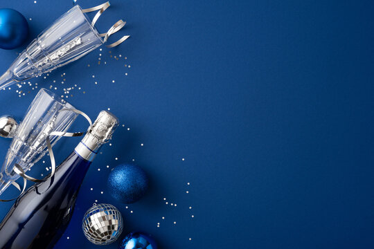 Happy New Year 2027 celebration with champagne glasses and blue holiday decorations on navy background