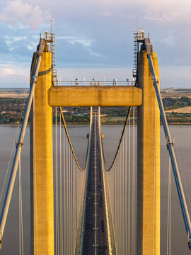 Humber Bridge Towers Rising Above the River Water During a Golden Sunset in East Yorkshire England