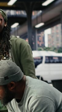Vertical frame: Couple embraces in a bus terminal before departure and holds each other tightly during an emotional goodbye, sharing a last hug before a long distance trip separates the two travelers.