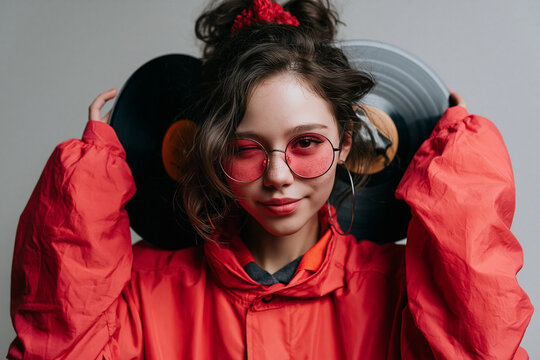 Stylish Young Woman Holding Vinyl Records in Retro Outfit
