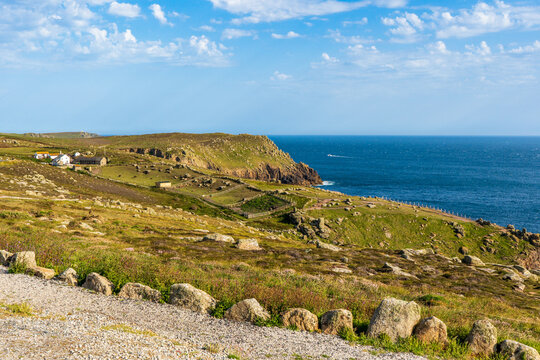 Rolling green hills and rocky sea cliffs at Land's End, Cornwall, UK.