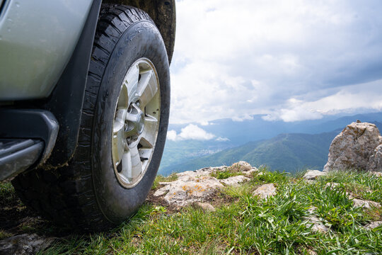 The car is parked on the edge of a mountain cliff.