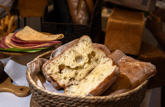 Freshly baked bread with golden crust and soft interior, resting on a rustic surface, evoking warmth, homemade baking tradition, and comforting bakery aroma.