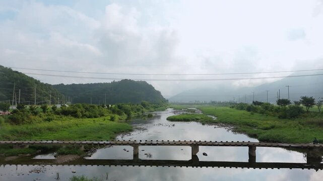 Early in the morning, I filmed the peaceful rural river with a drone. The small, low bridge suits the rural scenery.