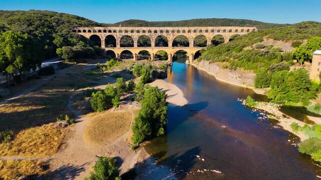 Aerial drone view of the Pont du Gard, the tallest surviving ancient Roman aqueduct from the 1st century with three tiers of arches, France. High quality 4k footage