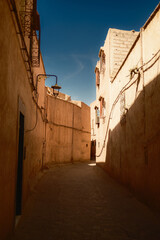 Obraz premium Narrow Sunlit Alley in the Marrakech Medina