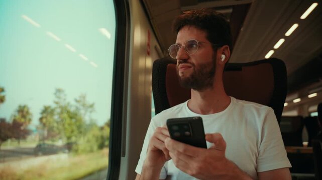 An Italian man listens to music on earbuds and sings while traveling by train