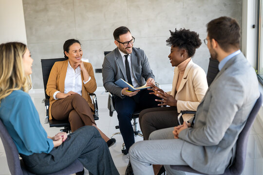 Multicultural professional businesspeople working together on research plan in boardroom.