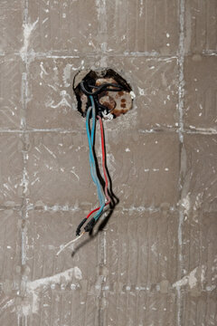 Junction boxes with exposed wiring and hanging colored wires. Focus on home electrical repairs and renovation for stock.