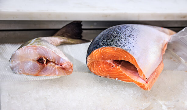 Fresh orange raw salmon and white cod fish tails at a food market, Sanremo, Italy