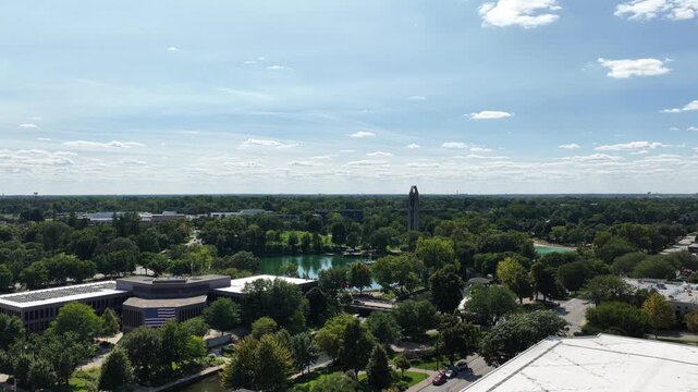  Aerial View of Downtown Naperville, Illinois with Lake and Lush Green Trees Under Blue Sky&rdquo;