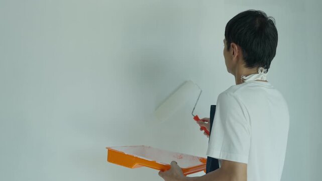 painter man, brush in hand for products to restore and paint the wall, indoor the building site of a house, wall during painting, renovation, painting, contractor, Architect, construction worker