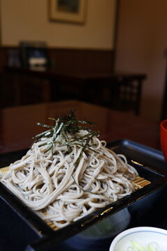 大盛りのざるそば。十割そば。海苔トッピング。黒い竹ざる。