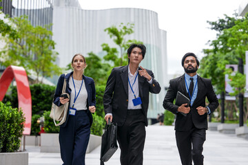 Three business colleagues walking toward the camera walk in step under the office towers in the...