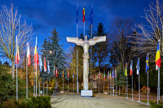 Monument with multinational flags at twilight. March 3, 2026, Suceava Romania