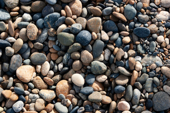 Natural pebble stones texture with smooth multicolored rocks, ideal for backgrounds and nature design.