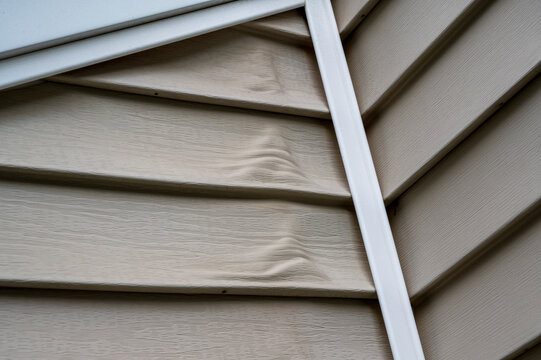 Close-up of heat-warped siding on aging house exterior