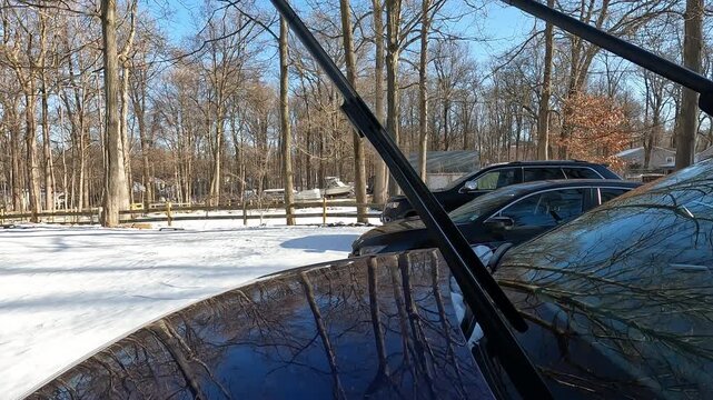 Berkeley Heights, NJ, USA - 02-15-2026: putting wipers down on windshield on sunny snowy day in February