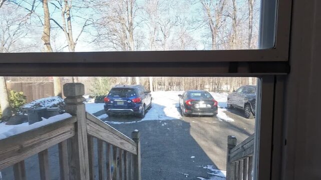 Berkeley Heights, NJ, USA - 02-15-2026: opening the door and going outside in the driveway on sunny snowy day in February