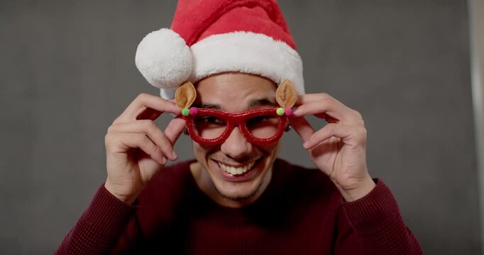 African-American man in Santa hat sweater laughing lifting wearing reindeer specs in studio for fun