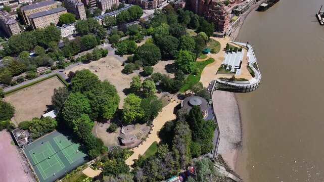 Riverside park with tennis courts, a bandstand and lawns beside the tidal foreshore, with a domed ventilation rotunda among the trees