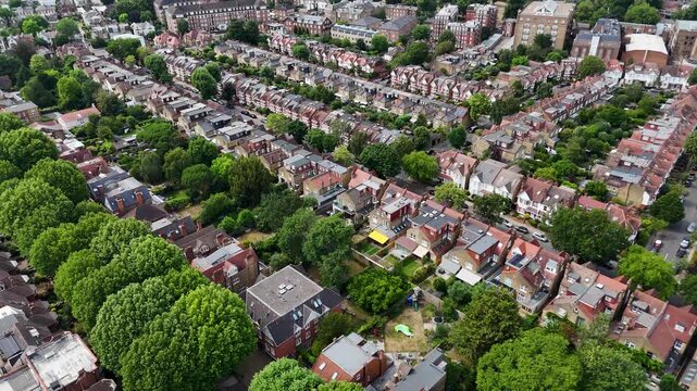Dense grid of terraced streets and rear gardens spreads across a leafy west London suburb toward open parkland