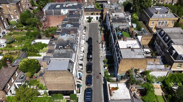 Narrow mews street with parked cars runs between converted stable houses and modern roof extensions in a prime residential quarter
