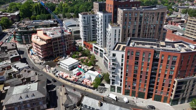 Tower crane stands among part built apartment blocks of a large town centre residential development, with completed towers alongside