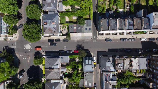Mini roundabout and a tree lined junction sit between terraces of period houses and their walled rear gardens