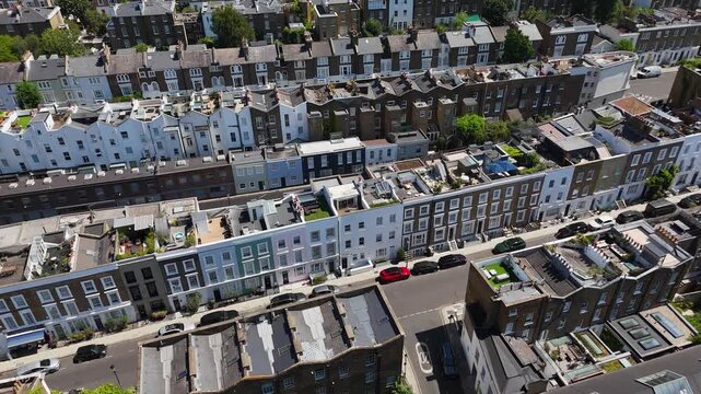 Rows of pastel painted terraces with rooftop extensions run along a residential street in a fashionable district