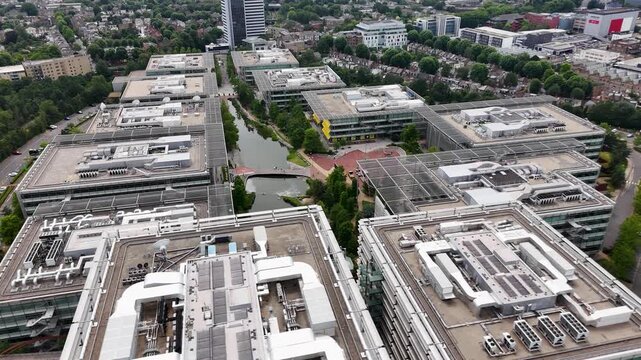 Rooftop plant, service walkways and glazed atria on the roofs of a modern office campus seen from above