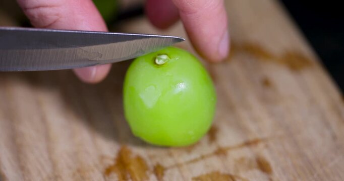 Pieces of sliced green grapes next to whole berries, halves of sliced green grapes with a translucent pulp texture on the kitchen table
