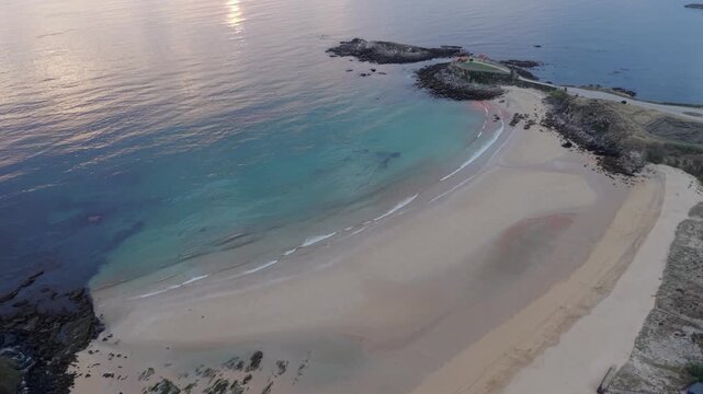 Sunset view of Ermita de la Lanzada chapel peninsula and sandy beach in Galicia Spain