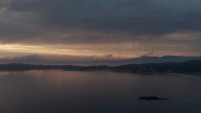 Aerial sunset view over Lanzada beach coast, calm Atlantic sea, and distant mountains in Galicia Spain