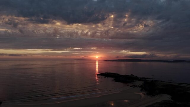 Sunset aerial view over Playa de la Lanzada sandy beach and calm Atlantic ocean in Galicia Spain