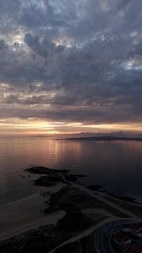 Vertical sunset aerial view over Ermita de la Lanzada peninsula and Atlantic coastline in Galicia Spain