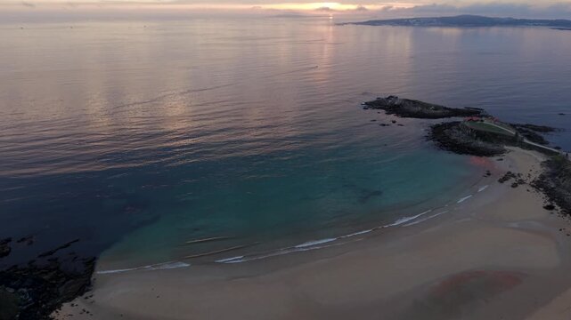 Aerial view over Praia de Paxos sandy cove with Ermita de la Lanzada peninsula and Atlantic ocean in Galicia Spain