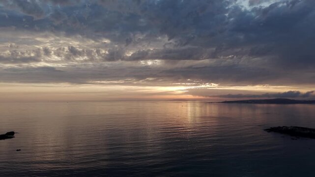 Sunset aerial view over calm Atlantic ocean waters off Praia de Paxos in Galicia Spain