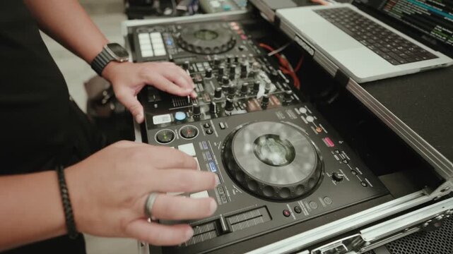 Hand on the Channel Faders of a DJ Controller Mounted in a Flight Case during a Set