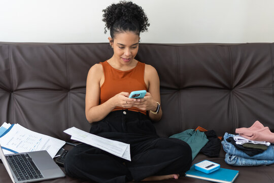 Woman multitasking working from home on sofa