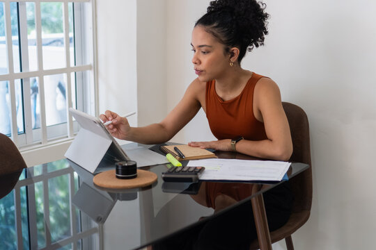 Woman working from home using tablet and stylus